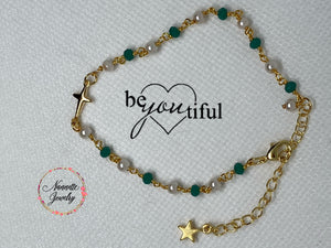 Pulsera con perlas y piedras verdes y con dije en forma de cruz